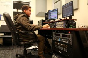 Senior Stevie Becker mixes a song in the sound recording studio