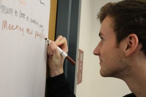 Junior Brendan Shepard writes on the wall during an activity about relationships and their impact on mental health.