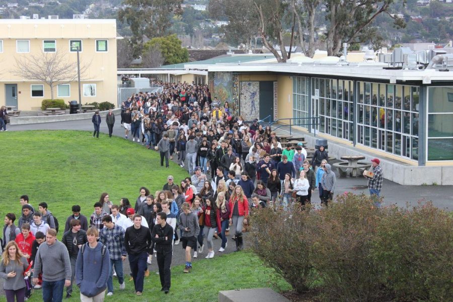 Students walk toward amphitheater after false fire alarm sounds during third period,