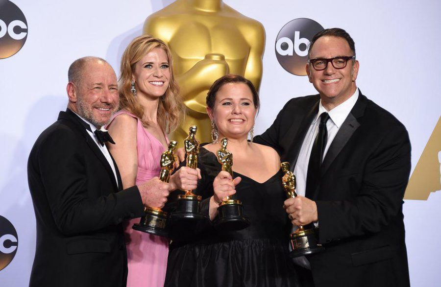Faust, second from left, celebrates her Academy Award with her co-producers.