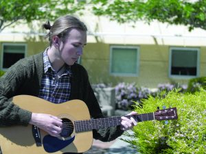 SENIOR JAKE BALDWIN rehearses on his guitar. Baldwin often uses music sharing sites like SoundCloud to share his musical talents.