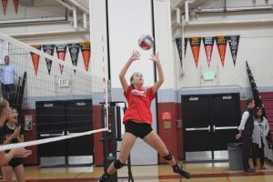 Freshman setter, Lucy Walsh, sets the ball to a teammate during warm-ups for the girls' varsity volleyball teams' game on Sept 13. 