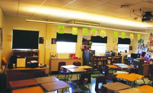 SITTING IN THE back of the room, Kemp works in a vacant classroom she shares stretching both facilities and teachers’ with Social Studies teacher Nikolai Butkevich.