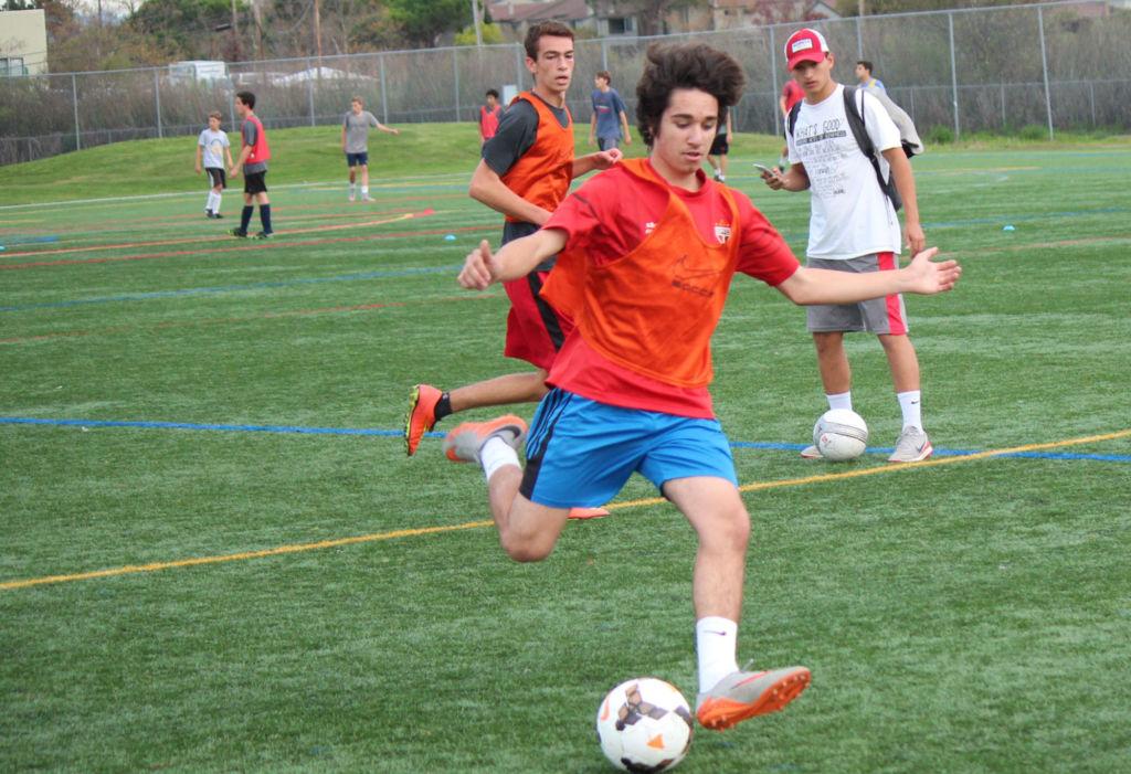 Kicking the ball, junior Lucas Quinto prepares for the season during try-outs.