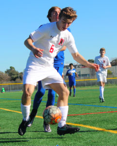 Sophomore Nathaniel Kuffner shields a defender as he controls the ball.