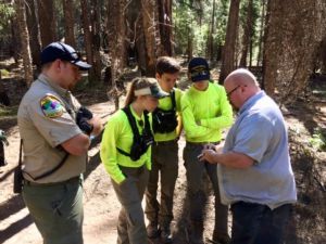 The team talks to a deputy after searching for a missing hunter in Mendocino.