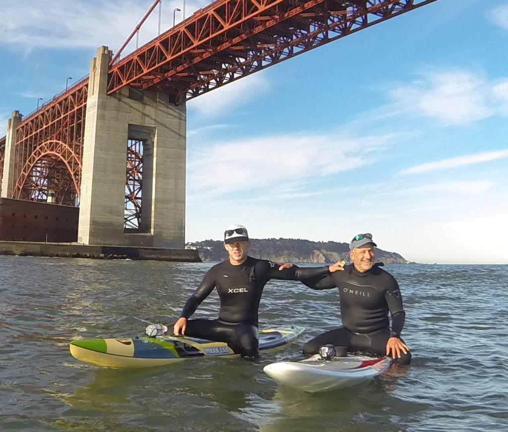 Holding on to his son Zacks shoulder, Cohen rides his board under the Golden Gate Bridge.
