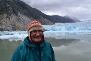 Smiling in front of a glacier, Cathy Connors is a professor at the University of Alaska Southeast