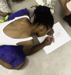 Little girl at Gaudin’s summer camp colors a drawing of a ballerina. 