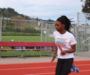 Baton in hand, Kohn sprints down the track to hand off to her teammate.
