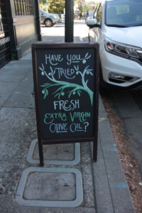 By their storefront, Amphora Nueva advertises fresh olive oil.
