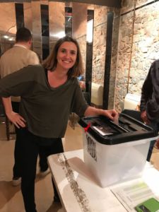 Placing her vote, Marta stands next to the ballot box.
