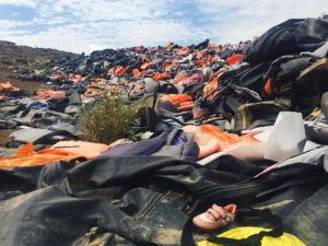 Discarded life jackets are thrown into a growing heap after refugees land on shore.