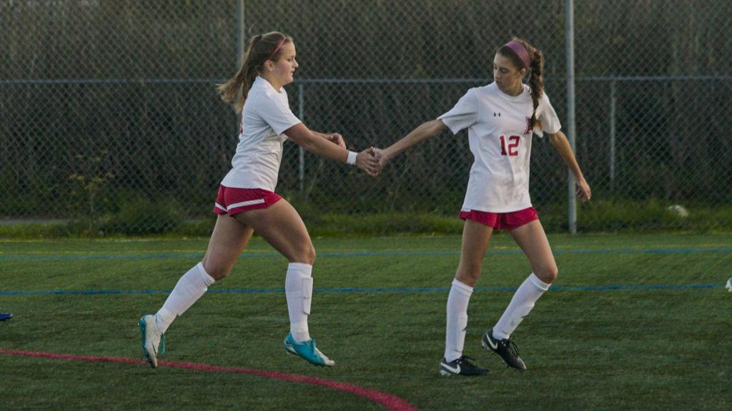 Senior Stella Campodonico and junior Maddie Perro high-five after a goal