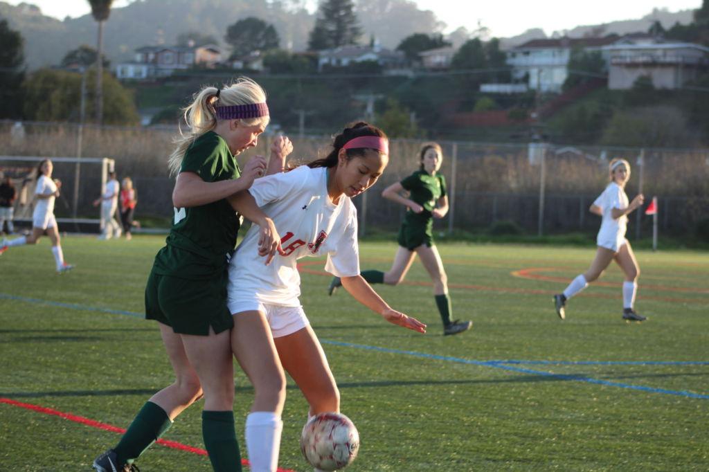 Blocking her competitor out of the way, junior Alexis Nunez defends the ball.