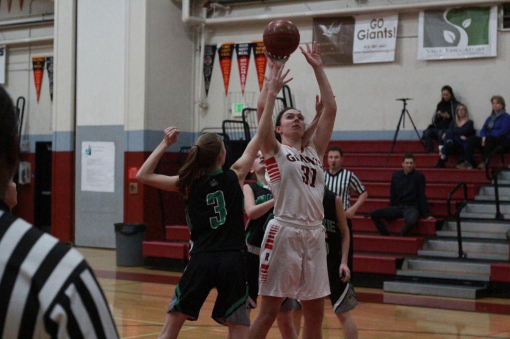 Senior center Julia Guisti rising above defenders for the lay in.