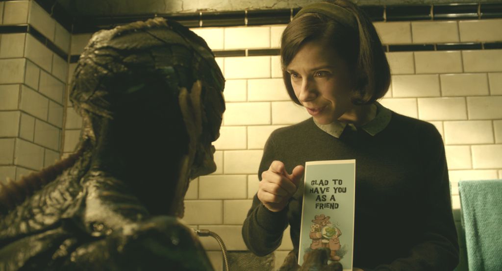 Sharing a brief moment of happiness together, Elise (Sally Hawkins) shows the creature (Doug Jones) a card she bought him. 