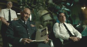 Conducting secret experiments, Colonel Stricken (Michael Shannon) and General Hoyt (Nick Searcy) contemptuously view the injured creature.