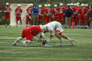Junior Miles Dean butts heads with an SI player to gain possession of the ball during a face-off.