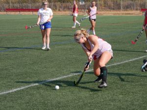 Dribbling down the field, freshman Lulu Hemley passes to a teammate.
