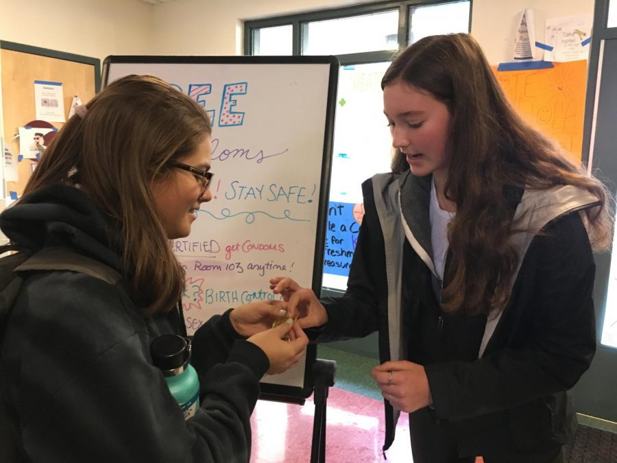 Junior Lyle Belger teaches junior Lindsey Dubin about how to properly use a condom during the condom-certification event organized by Peer Resource at lunch. The event strived to promote safe sex and increase awareness about birth control. 