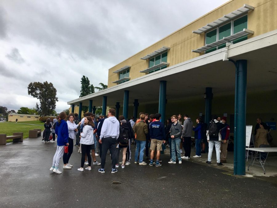Despite rainy skies, students crowd around the small gym to collect materials for their AP exam during the second week of testing.