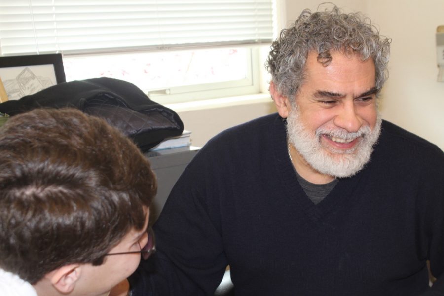 Ernesto Diaz laughs while helping a student with his homework.