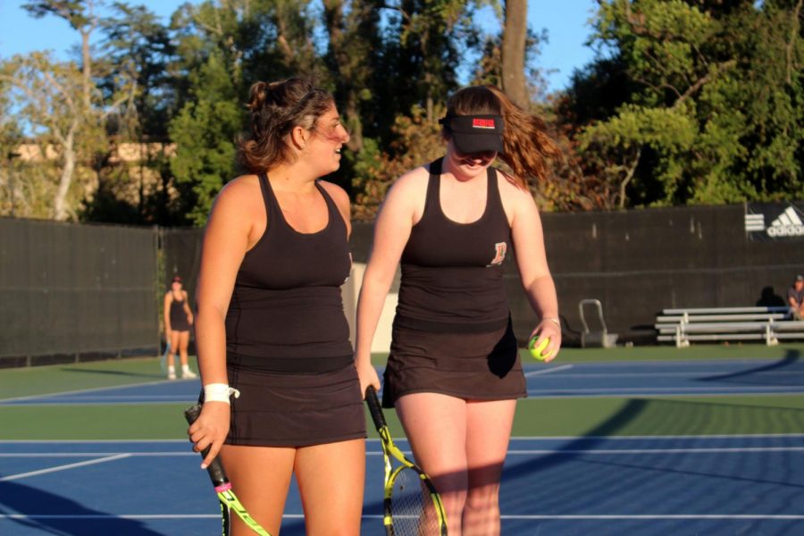 Senior doubles partners Vanessa Comins and Zoe Babikian remain light-hearted during their competitive match. 
