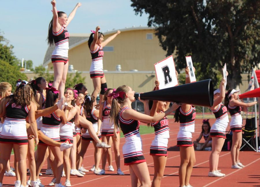 Performing in front of packed stands, the Redwood cheerleaders display their support for the football team in the homecoming game against San Rafael High School, just hours before the PG&E power outages began which caused the homecoming dance to be cancelled.