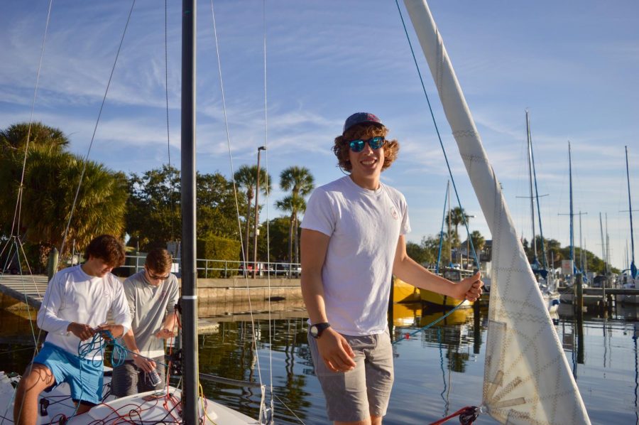 Rigging his boat with his teammates, Yoslov is optimistic about their upcoming day of racing. 
