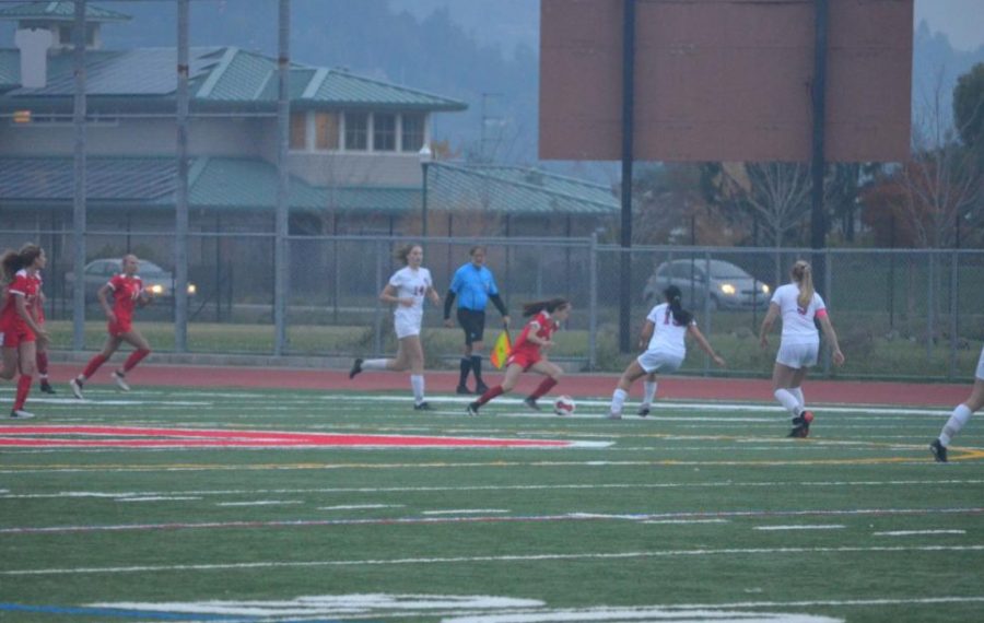 The girls’ varsity soccer team battles Tamalpais High School through the rain.
