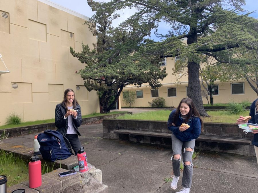 Redwood Juniors Ava Converse and Emily Fieber have a socially distant lunch in the rain.