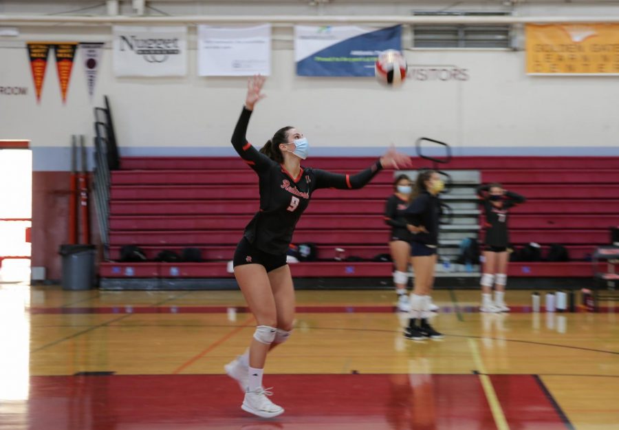 Launching the ball into the air, Green serves across the court at a home game against San Rafael High School. 