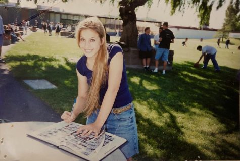 Posing with her yearbook, high schooler Allison Kristal (Class of ‘98) stands on the Redwood campus. (Courtesy of Allison Kristal)