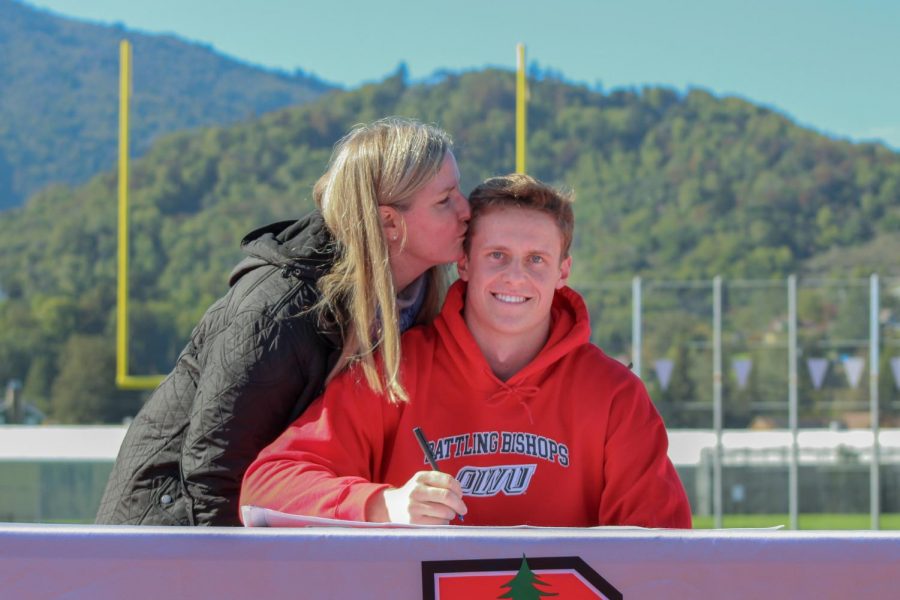 Kissing him on the cheek, Dennis Van Der Wal’s mom congratulates her son after he officially signed to play lacrosse at Ohio Wesleyan University.
