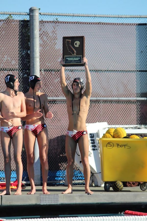 Senior water polo captain Marco Asiano hoists the California Interscholastic Federation plaque after the Giants’ win against Jesuit. (Photo by Sam Michaels)
