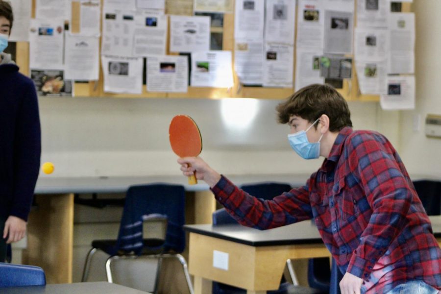 Striking the ball, junior Alec Marasa competes in a ping pong tournament during SMART class.