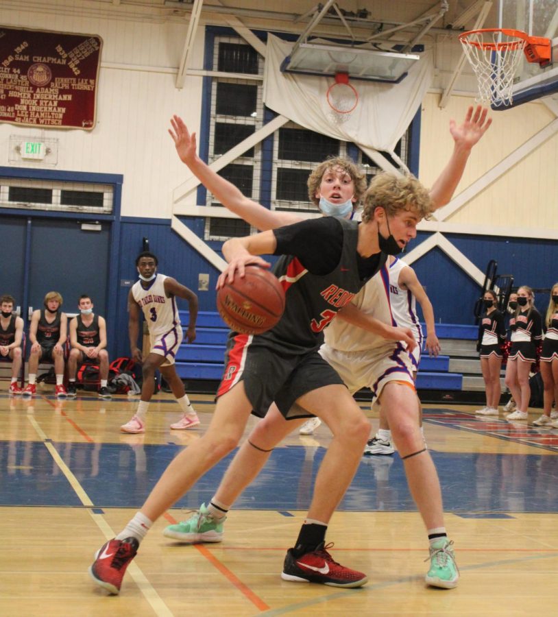 Dribbling the ball, senior Charlie Treen attempts to score in the second quarter of the Redwood vs. Tam varsity basketball game.