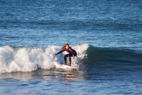 Katie Slevin shifts her balance to catch a left wave at Rodeo Beach as she looks down the line. 