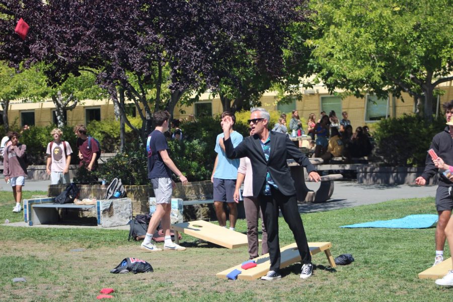 Staring down his bean bag toss, Principal Barnaby Payne joins Redwood students at the first Lawn Chair Friday of the year. 