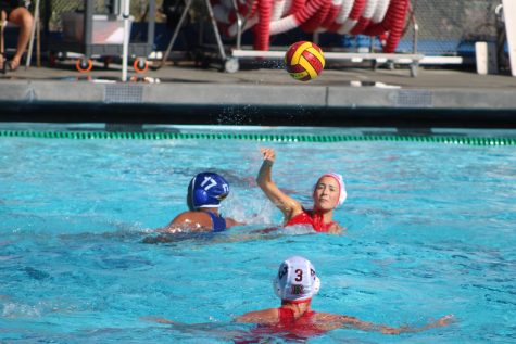 Passing the ball to a fellow teammate, Annika Danne starts in Water Polos Varsity Girls first game. 