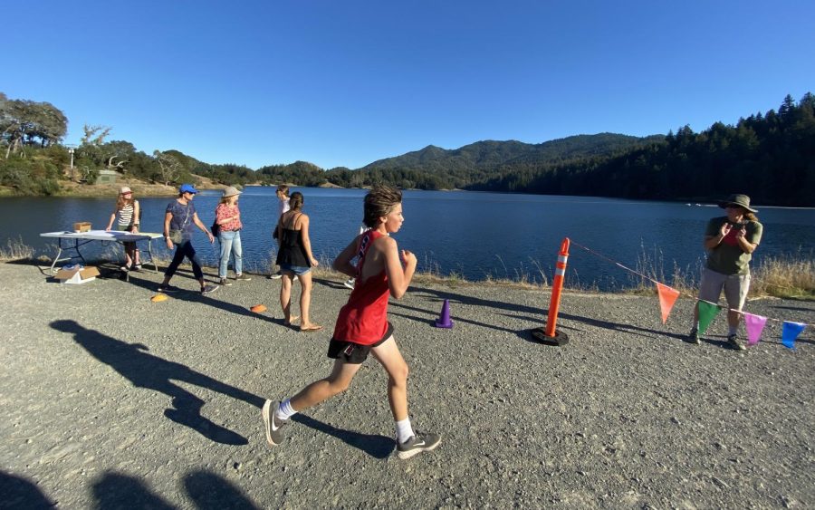 Racing across Bon Tempe Dam, a cross-country runner crosses the halfway mark of the course.