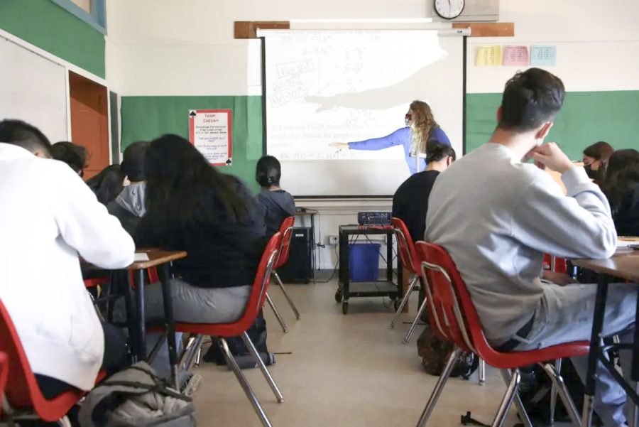 Demonstrating a pre-calculus concept, a high school math teacher instructs her students on math skills which, compared to reading, are harder to master without instruction.  (Image courtesy of the New York Times)
