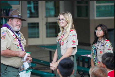 Standing in front of her fellow scouts, Corinne Hunt waits to receive her 13 merit badges in her troop court of honor. (Photo courtesy of Corinne Hunt)