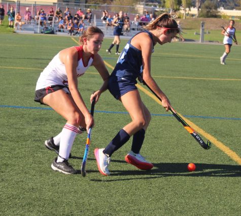 Charging towards an opponent, junior Maisie Pipitone works hard to win the ball back for the team. 