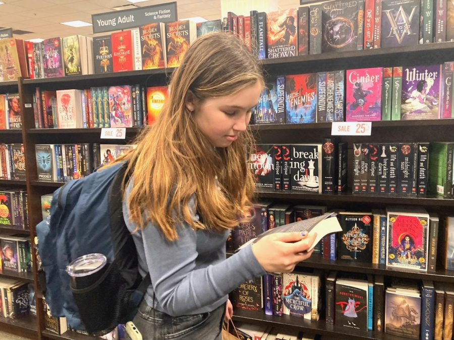 Taking a look at the summary on the back of a novel, junior Hannah Ritola decides to take advantage of the sale and purchase a book.