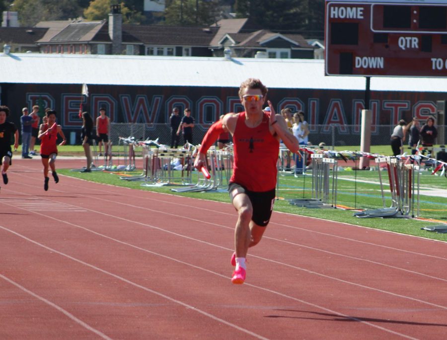 Sprinting to the finish line, senior Baden Bunch wins the 4x100 relay race for the Giants. 