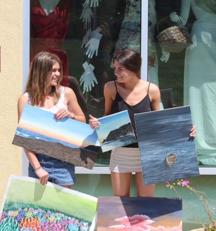 Two AP Art students display their work, all of which has prepared them to paint the mural. (Photo by Lauren Poulin)