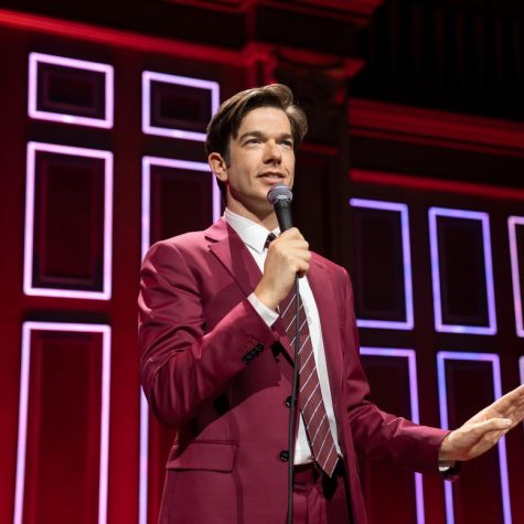 Speaking to a packed audience in the Boston Symphony Hall, John Mulaney performs a stand-up set inspired by his time in rehab. (Image courtesy of Netflix)