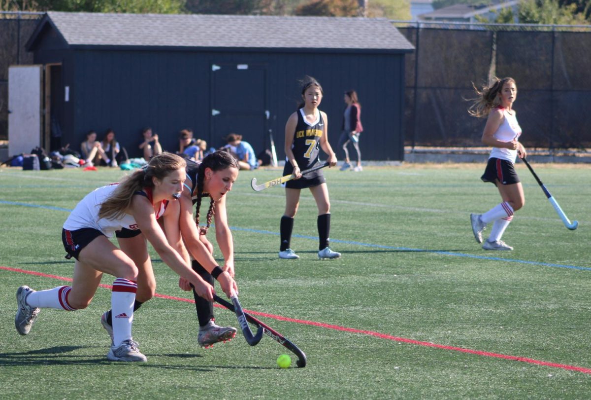 Neck and neck with a Lick-Wilmerding attacker, senior Amanda Mueller reaches for the ball.
